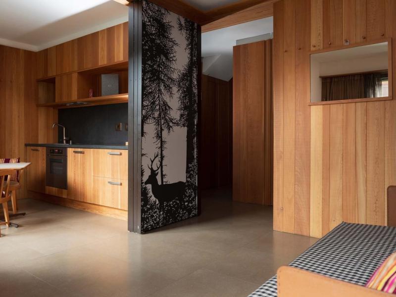 Interno in legno con cucina moderna e pannello decorativo con cervo.