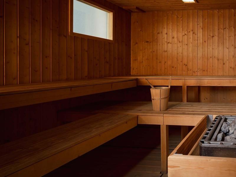 Sauna in legno con secchio, mestolo e pietre riscaldanti.