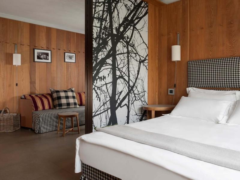 Camera da letto moderna con legno, letto matrimoniale e decorazioni in bianco e nero.